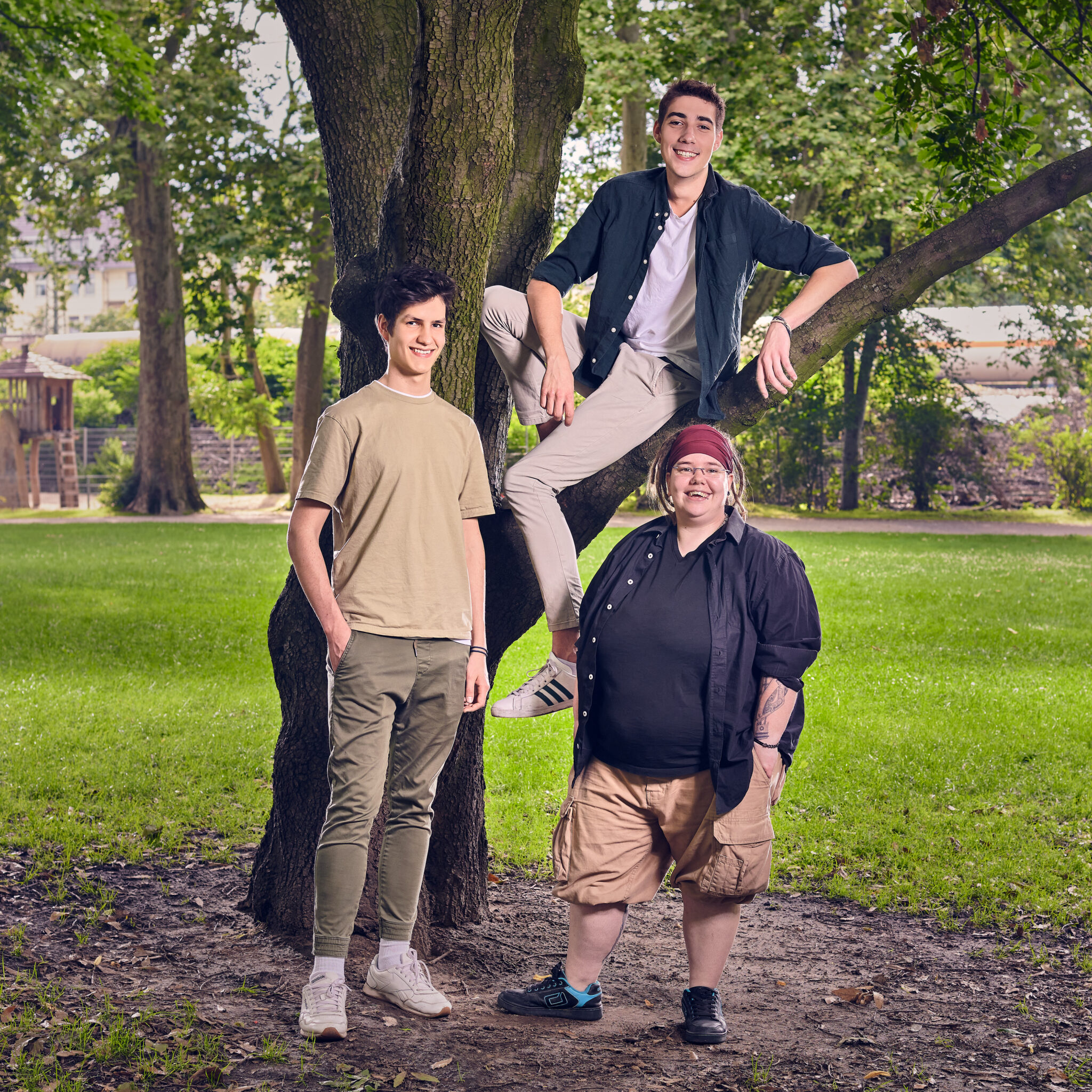 Teamfoto mit drei jungen Menschen an einem Baum